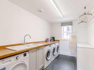 a kitchen with a sink and washing machines at 1 Bed in Cadgwith 82496 in Ruan Minor