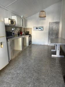 a large kitchen with a table and a refrigerator at Casa en Paso II in Paso de la Patria