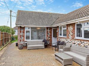 a brick house with a patio with couches and chairs at 2 Bed in Bacton 75392 in Bacton