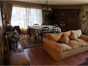 a living room with a couch and a table at Hostal Edificio Kuramochi in Temuco +5 photos