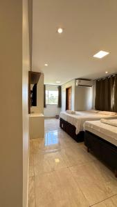 a hotel room with two beds and a bathroom at Casa Gold Condominio Estancia Jussara in Barreirinhas