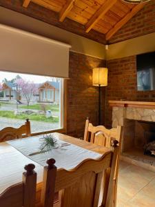 a dining room with a table and a fireplace at Land Park - Hostería y Cabañas in Junín de los Andes