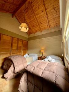 a bedroom with two beds in a room at Land Park - Hostería y Cabañas in Junín de los Andes
