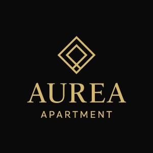 un logo en or sur fond noir dans l'établissement AUREA Apartment, à Prizren