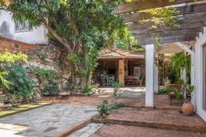 an outdoor patio with a tree and a brick building at Casa Eva, rústica y cálida familiar in Asuncion