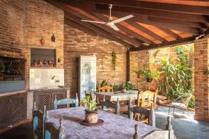a patio with a table and a ceiling fan at Casa Eva, rústica y cálida familiar in Asuncion