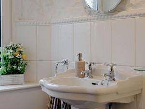 a bathroom with a white sink and a mirror at 3 Bed in Alston 89994 in Slaggyford +17 photos