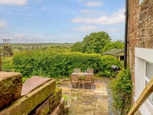a patio with chairs and a table in a yard at 2 Bed in Egremont 87227 in Egremont