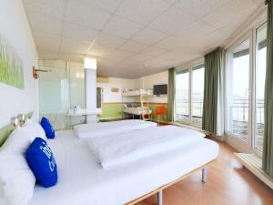 a hospital room with two beds and a large window at ibis budget Hotel BONN SÜD Königswinter in Königswinter