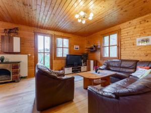 a living room with leather couches and a table at Karawankenpanorama in Liebenfels