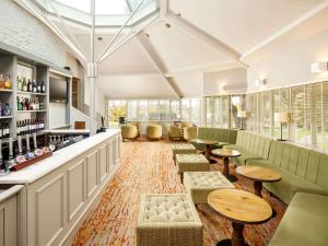 a bar with tables and chairs in a room at Mercure Bristol North The Grange Hotel in Bristol
