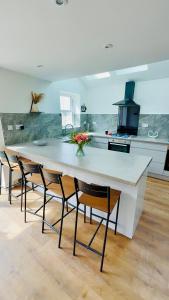 a large kitchen with a large white table and chairs at DSK Residencia in Maidstone