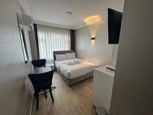 a small bedroom with a bed and a table and chairs at Old City Kadıköy Otel in Istanbul