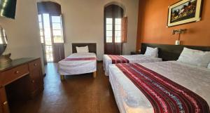 a hotel room with two beds and two windows at La Casona de Jerusalen in Arequipa +10 photos