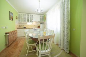 uma cozinha com uma mesa e cadeiras e um frigorífico em Holiday House Kod Ajke em Slunj