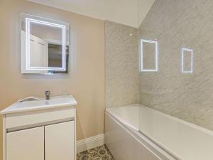 a bathroom with a sink and a tub and a mirror at 3 Bed in Tollerton 87290 in Tollerton +14 photos