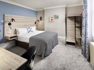 a hotel room with a bed and a closet at Mercure Brighton Seafront Hotel in Brighton & Hove