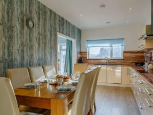 a dining room with a wooden table and chairs at 4 Bed in Newquay 90325 in Newquay
