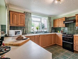 a large kitchen with wooden cabinets and a window at 3 Bed in Briston 90184 in Briston +9 photos