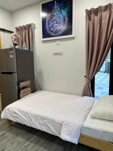 a bedroom with a bed and a painting on the wall at Rumah Tamu Sonata in Seremban