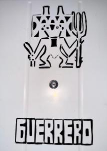 a white door with black graffiti on the wall at Hospedaje Maité in Santa María