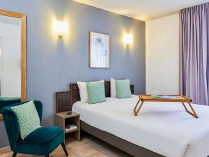 a room with a bed and a table and a chair at Aparthotel Adagio Access Nice Garibaldi in Nice