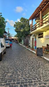 a cobblestone street in a town with a building at Apart Lua Crescente - de casal até 5 pessoas na Pituba caminho das praias in Itacaré +13 photos