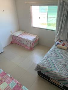 a bedroom with two beds and a window at pousada Requenguela in Icapuí
