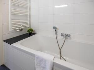 a white bath tub in a white bathroom at Assum Great in Uitgeest +14 photos