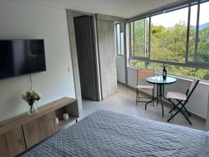 a room with a bed and a table and a television at Apartamento Living in La Ceja