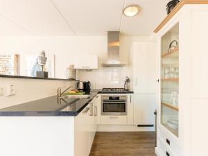 a kitchen with white cabinets and a sink at Assum Great in Uitgeest