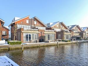 a row of houses next to a body of water at Assum Great in Uitgeest