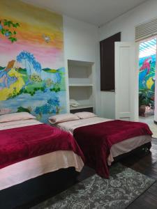 a bedroom with two beds and a painting on the wall at Casa Prado Centro in Medellín
