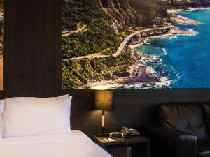 une chambre d'hôtel avec un lit et une vue sur l'océan dans l'établissement Mercure Gerringong Resort, à Gerringong