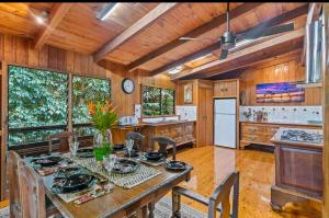 a large kitchen with a wooden table and chairs at Kalamunda - A Home in the Forest in Bayview Heights