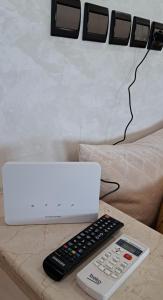 a laptop and a remote control on a table at Appartement Calme et Jolie près de l'aéroport in Oulad Tayeb +25 photos