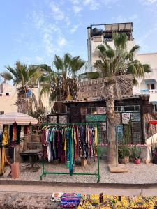 un magasin avec un portant de vêtements devant un bâtiment dans l'établissement TISLIT Surf Taghazout, à Taghazout