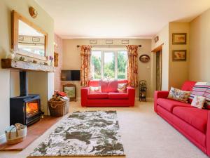 sala de estar con 2 sofás rojos y chimenea en 3 Bed in Thirsk 88464, en Bagby