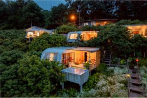a group of mobile homes in the woods at night at เดอะ ม้ง โฮมสเตย์ The Hmong Home Stay Chiangmai in Ban Tai