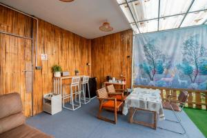 a room with wooden walls and a table and chairs at เดอะ ม้ง โฮมสเตย์ The Hmong Home Stay Chiangmai in Ban Tai