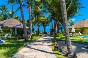 a walkway through a resort with palm trees at Nannai Residence - Flat de luxo in Porto De Galinhas