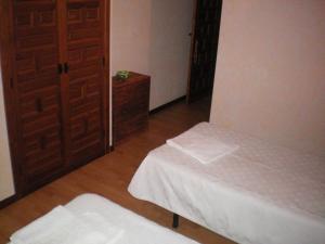 San ViteroにあるHotel Rural Los Peralesのベッド2台とドアが備わる小さな部屋です。