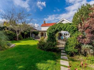 un jardín con un arco frente a una casa en 4 Bed in Bembridge IC070, en Bembridge