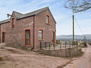 une ancienne maison en briques avec une clôture sur un chemin de terre dans l'établissement 2 Bed in Llangorse 91085, à Llangorse