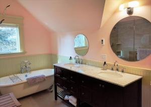 a bathroom with two sinks and a tub and a mirror at Evermore Guesthouse in Portland