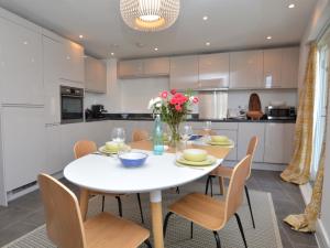 a white kitchen with a white table and chairs at 2 Bed in Bournemouth 48516 in Bournemouth