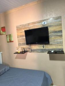 a flat screen tv on a wall in a bedroom at Espaço Foz in Foz do Iguaçu