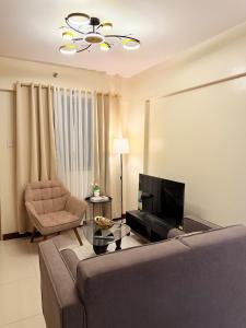 a living room with a couch and a chair at Staycacia Haven 2BR Condo Maple Acacia Taguig in Manila +24 photos