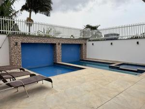 a swimming pool with two chairs in front of a building at Da Silva Chalé in Santa Lídia