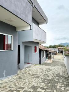a house with a stone driveway in front of a building at Da Silva Chalé in São Lídio